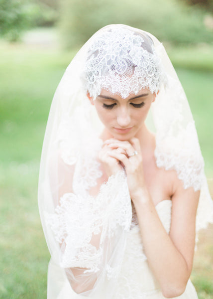 close up of bride wearing chantilly lace mantilla with wide border.