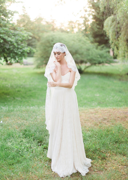 bride in garden wearing chantilly lace mantilla in waltz length and lace dress