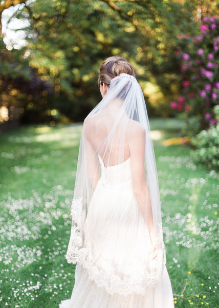 back view of bride wearing a fingertip chantilly lace veil.